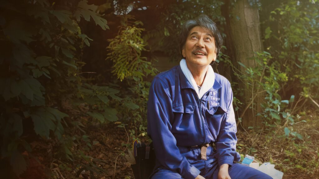 Film inspirant Perfect Days : Hirayama admire la lumière du soleil qui se faufile entre les branches
